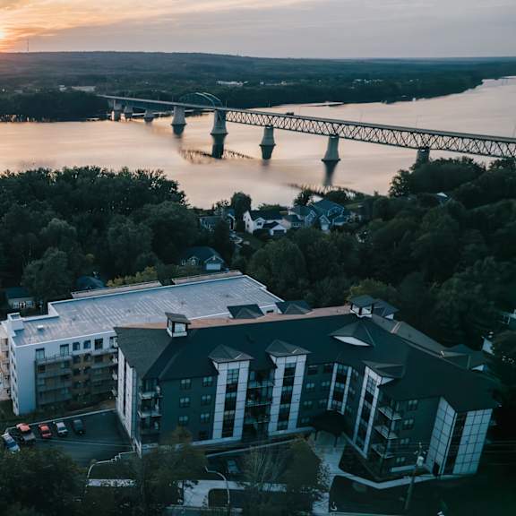 a bridge spans a river in the distance, with a building in the foreground.