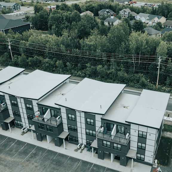 a row of identical buildings are seen from above.