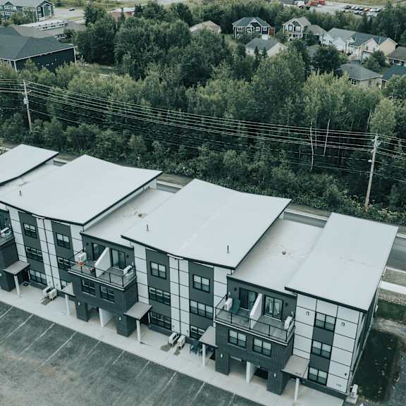 a large building complex with multiple buildings and a parking lot in front.