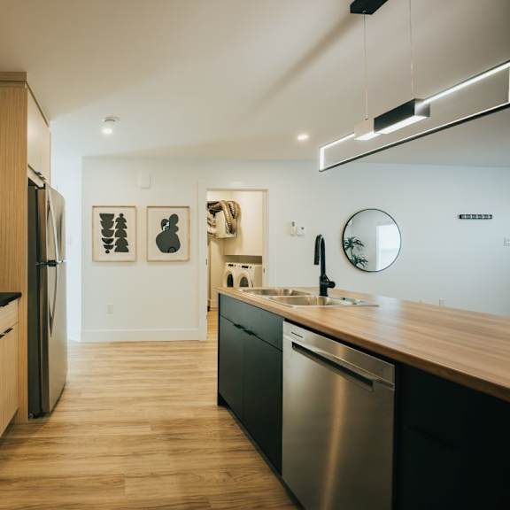 a modern kitchen with wooden cabinets and stainless steel appliances.