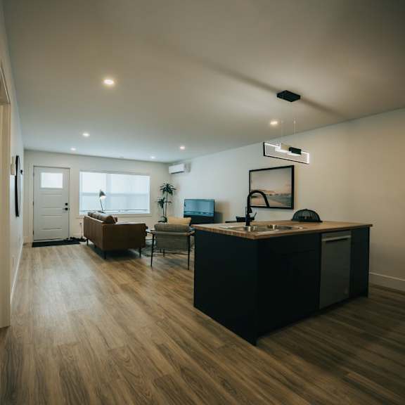 a modern kitchen with a wooden floor and a large island.