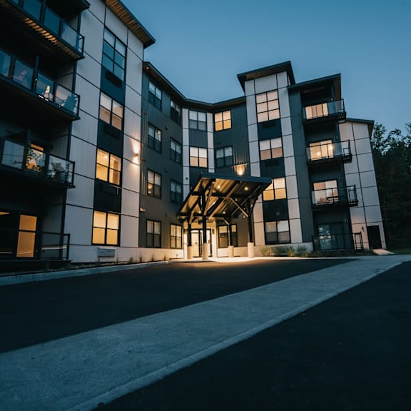 a modern apartment building with a curved design and multiple balconies.