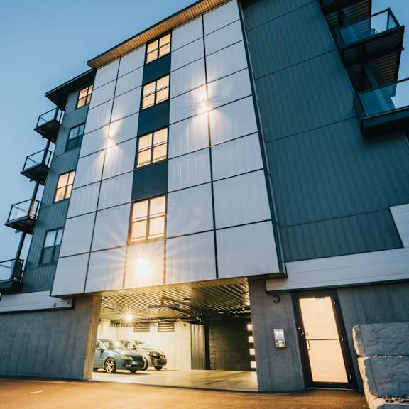 a modern building with a large glass window and a car parked in the garage.