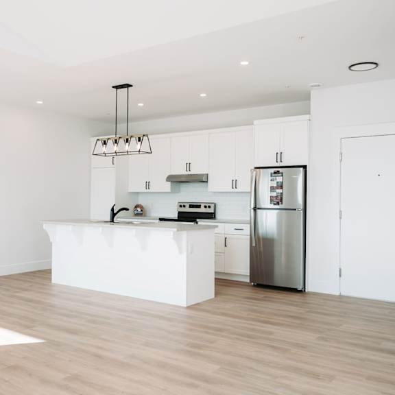 a kitchen with a white island and stainless steel appliances.