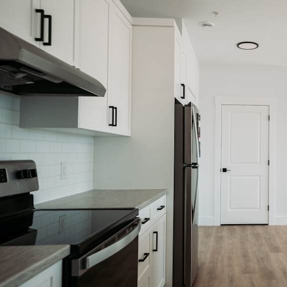 a kitchen with a black counter top and white cabinets.