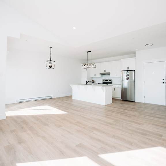 a kitchen with a refrigerator, sink, and cabinets.