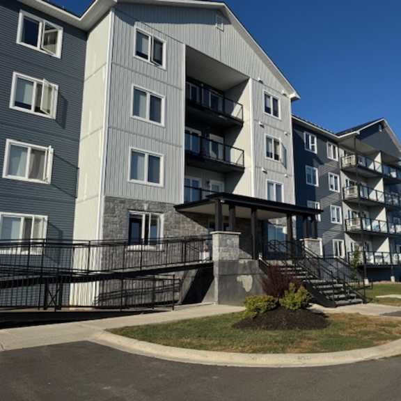 a large apartment building with a black fence in front.
