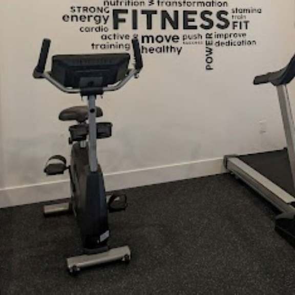 a gym room with a treadmill and a stationary bike.