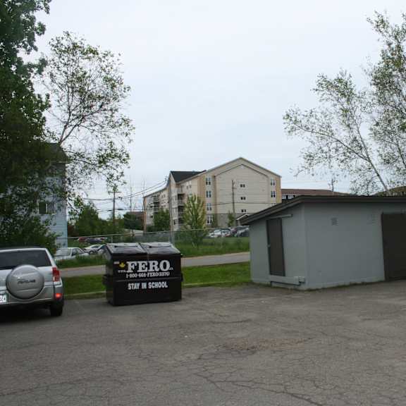 a parking lot with cars and a building in the background.