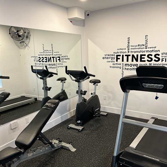 a gym with a treadmill and a sign that says "fitness".