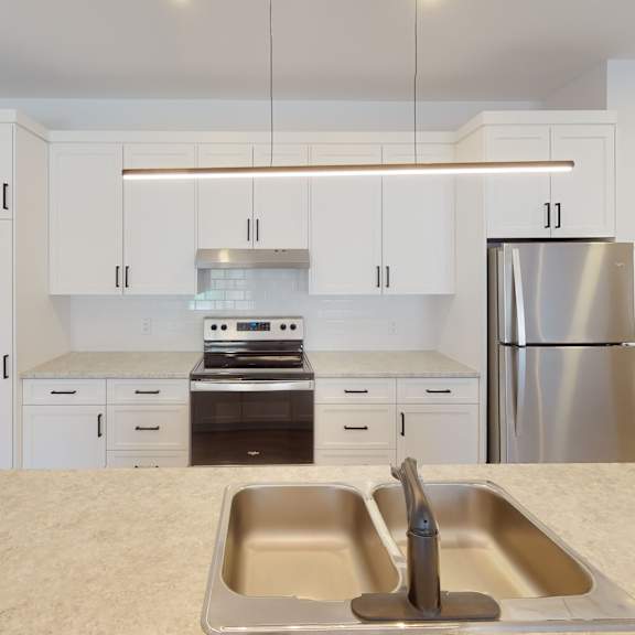 a kitchen with a sink, stove, and refrigerator.