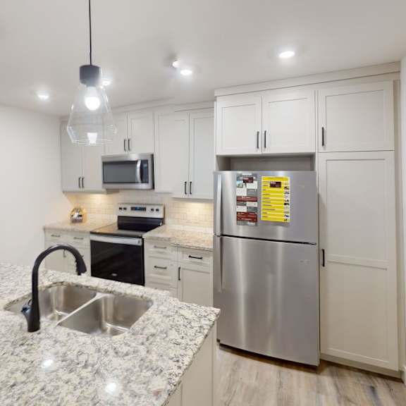 a kitchen with a granite countertop and stainless steel appliances.