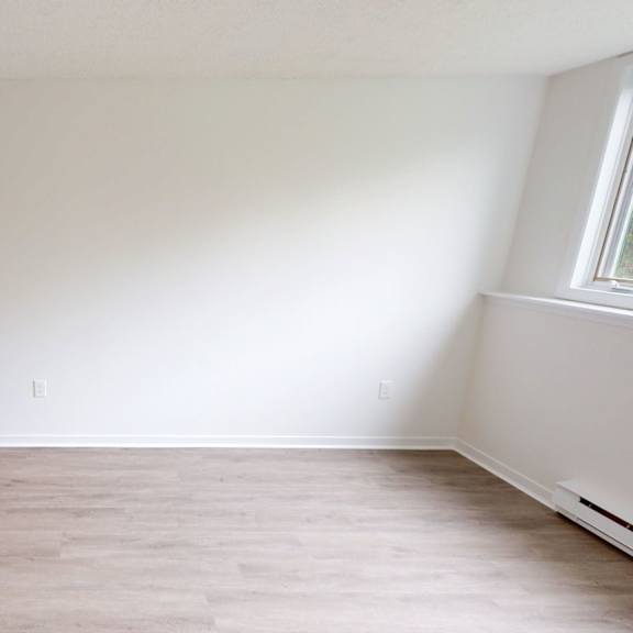 a room with wooden flooring and a window on the wall.