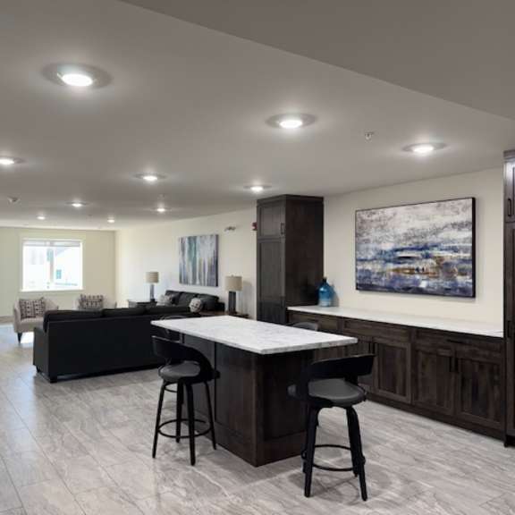 a modern kitchen with a bar area and a painting on the wall.