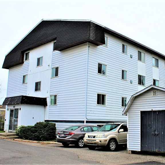a white building with a black roof and a black door.