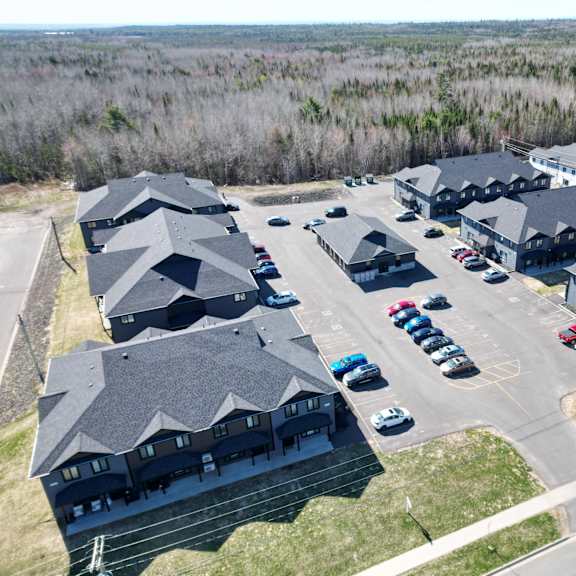 a parking lot with cars and a building in the background.