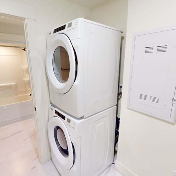 a white washing machine and dryer in a small laundry room.