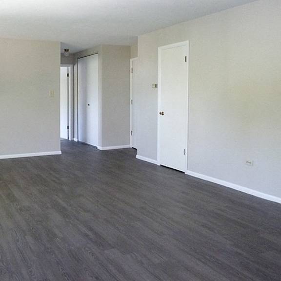 a room with wooden flooring and white walls.