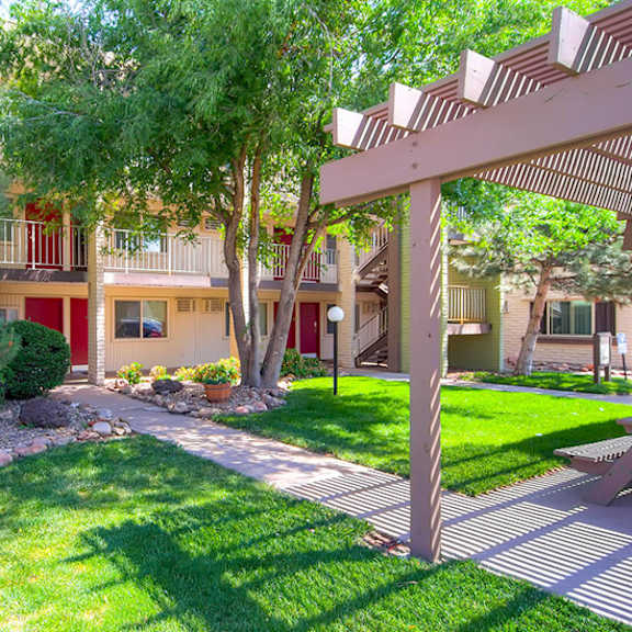 a well-maintained lawn and a building with a red door in the background.