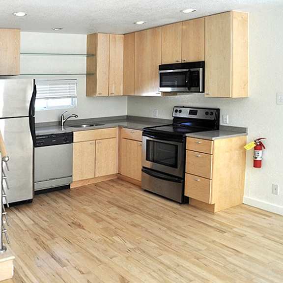 a kitchen with wooden cabinets and a staircase.