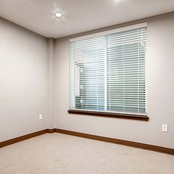 a room with a window covered by white blinds.