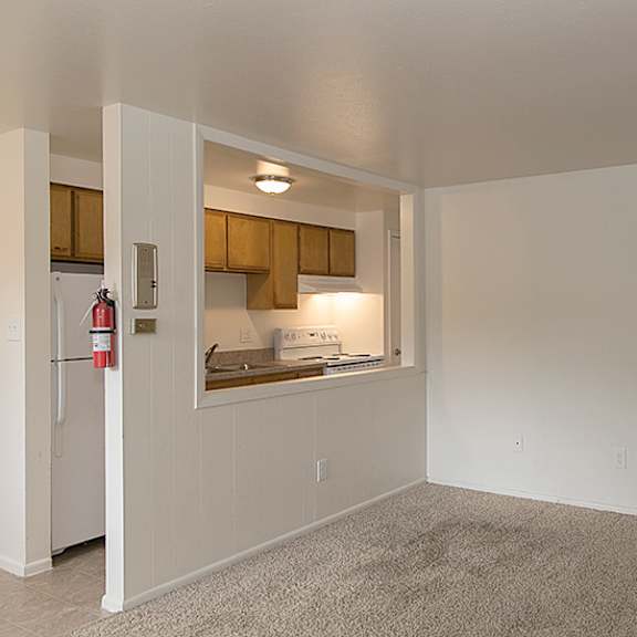 a kitchen area with a refrigerator, cabinets, and a countertop.