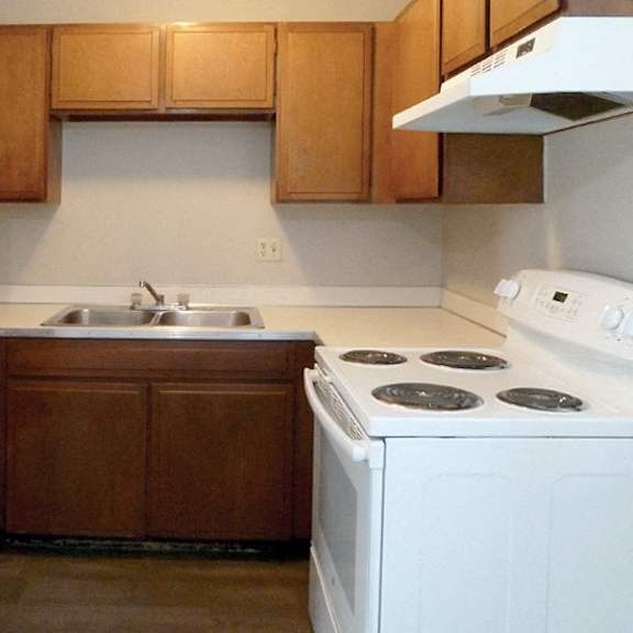 a white refrigerator stands next to a white stove in a kitchen.