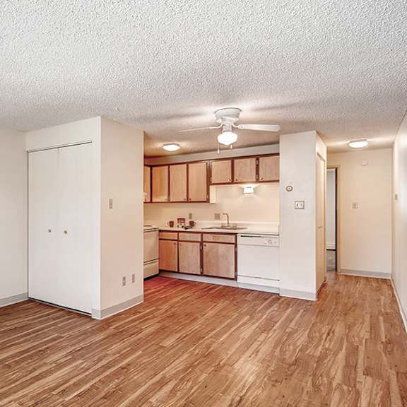 a kitchen area with wooden floors and white walls.