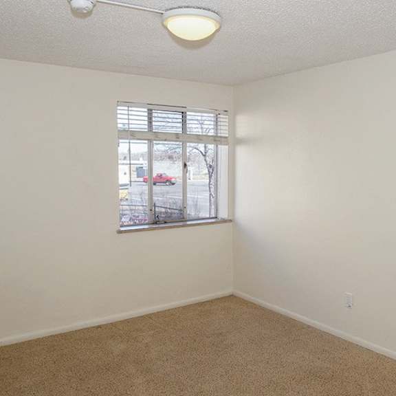 a room with a window and a car parked outside.