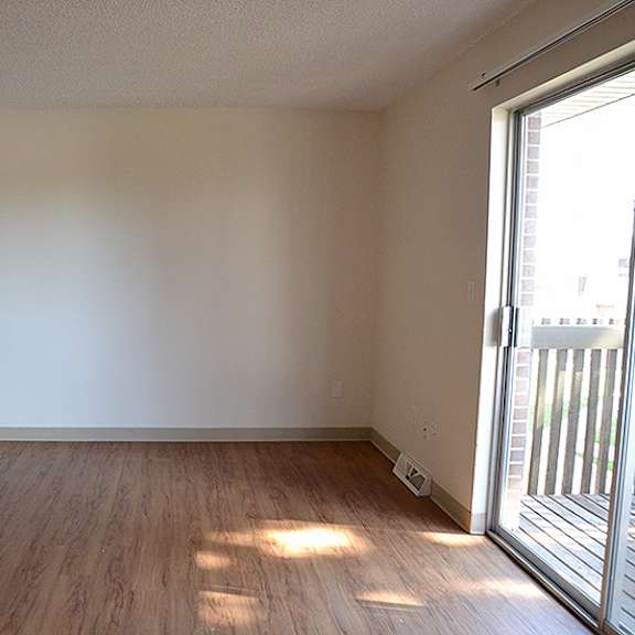 empty room with wooden floor and sliding glass door.
