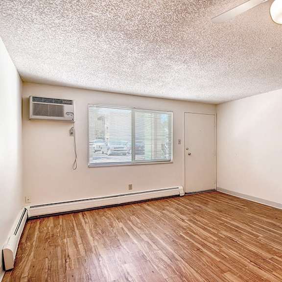 a room with wooden floors and white walls.