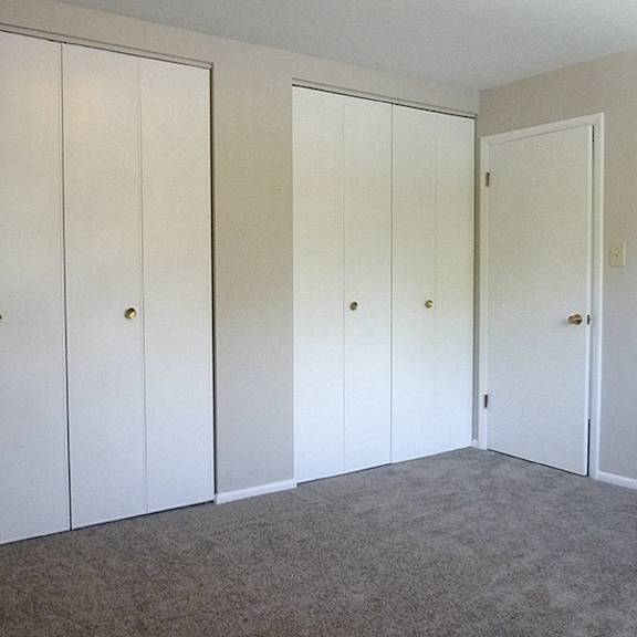 a room with three white doors and a carpeted floor.