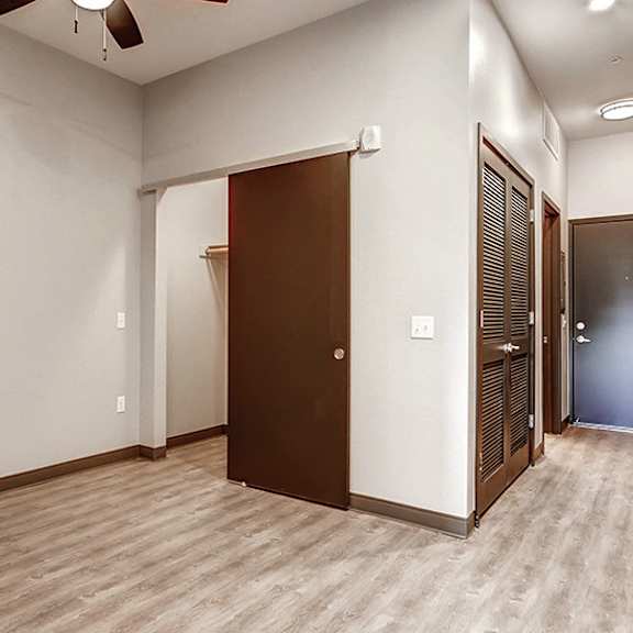 a room with a brown door and a fan on the ceiling.