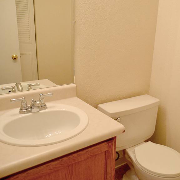 a white toilet sits next to a sink in a bathroom.