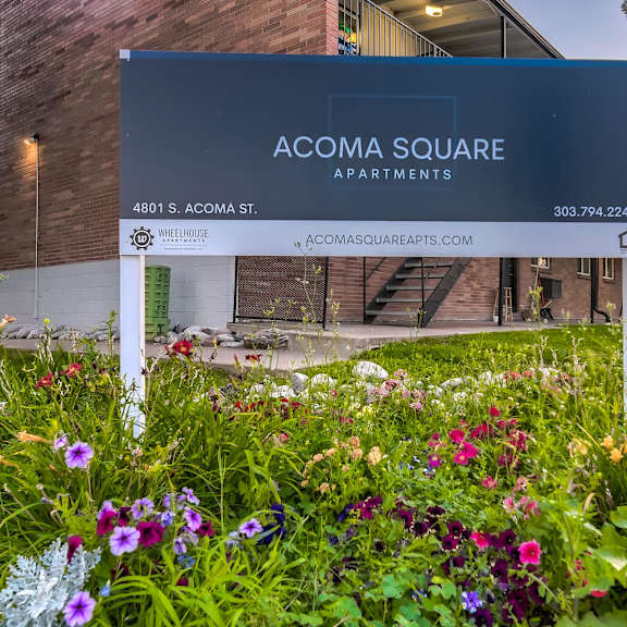 a sign for acoma square apartments is in front of a building.