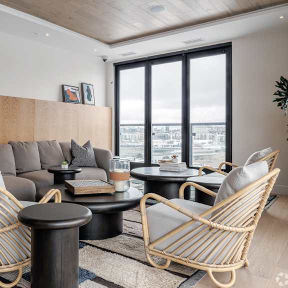 a living room with a grey sofa, two chairs and a table.
