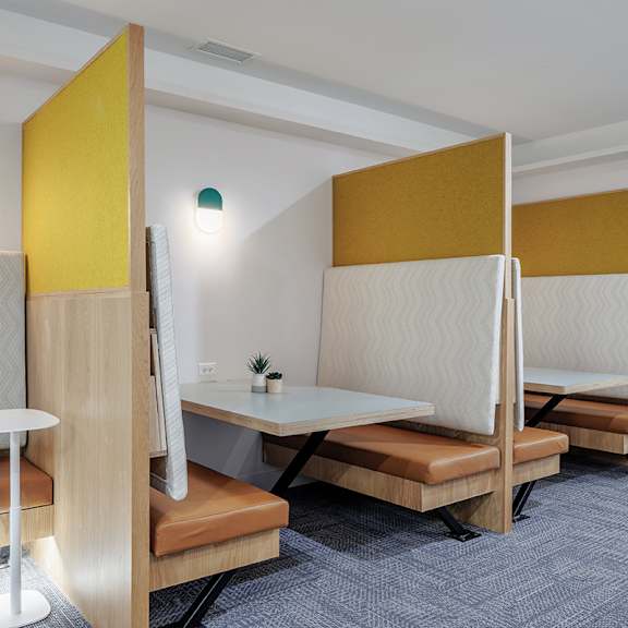 a room with a desk, chairs and a plant.