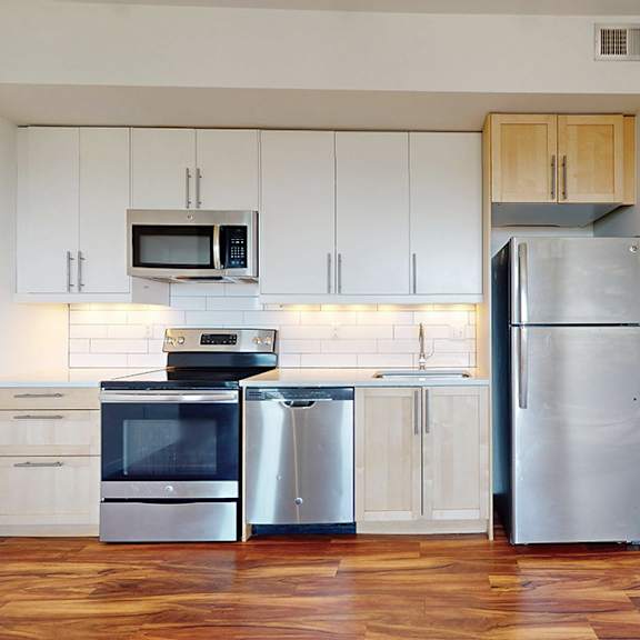 a kitchen with a refrigerator, oven, and microwave.