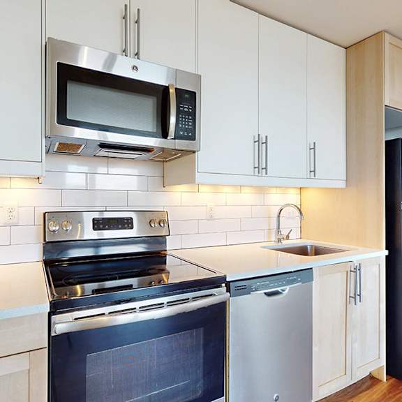 a kitchen with white cabinets and a black stove top oven.
