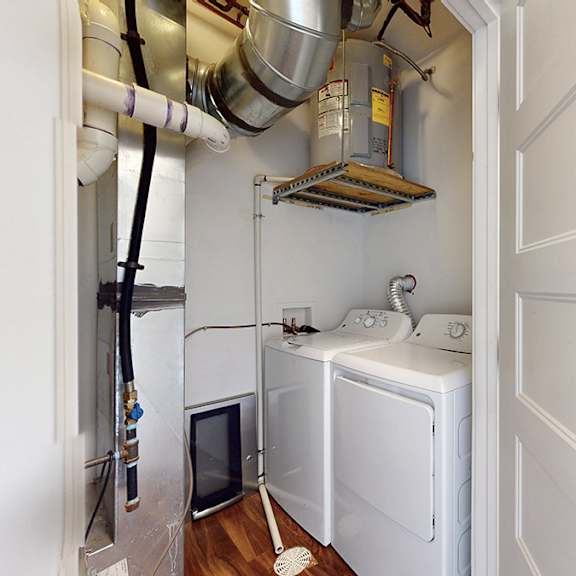 a small kitchen with a refrigerator, oven, and washing machine.