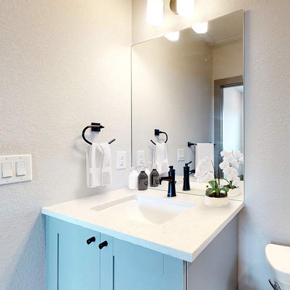 a bathroom with a blue cabinet and a white sink.