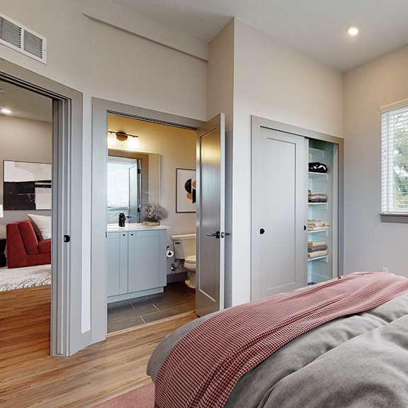 a bedroom with a large bed and a window with a view of trees.