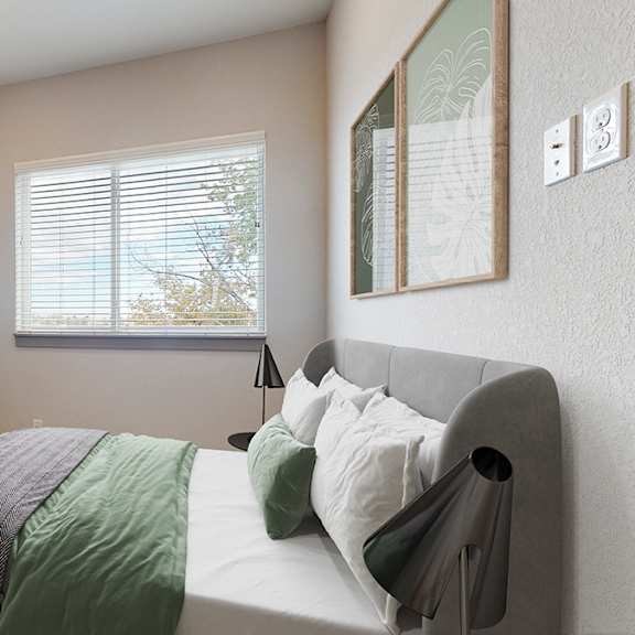 a bedroom with a bed, a television, and a window with blinds.