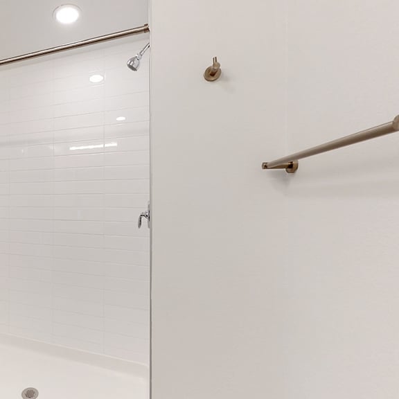 a white bathroom with a glass shower door.