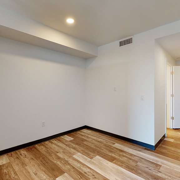 a room with wooden flooring and white walls.