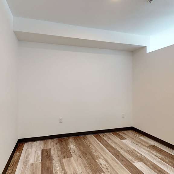 a room with wooden flooring and white walls.