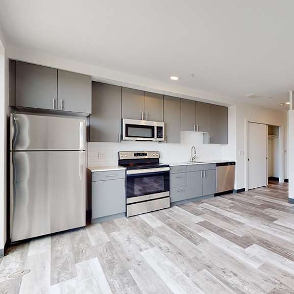 a kitchen with a refrigerator, oven, and microwave.