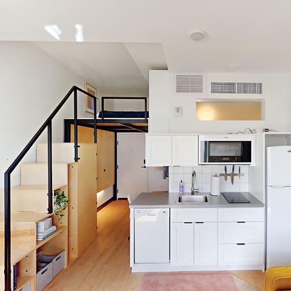 a kitchen with white cabinets and a white fridge.