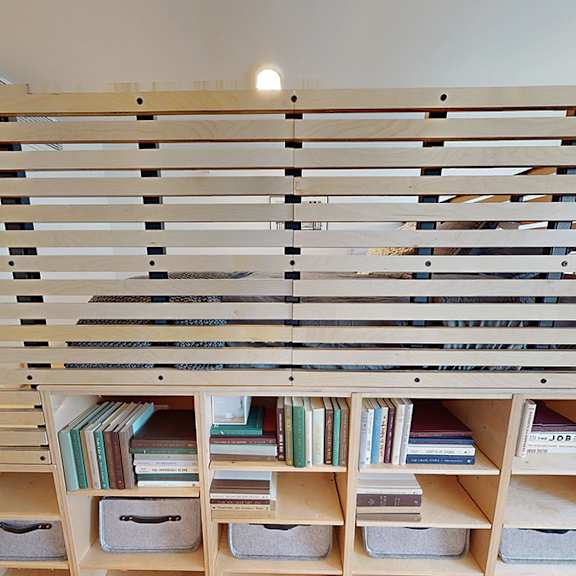 a bookshelf with books and a window.