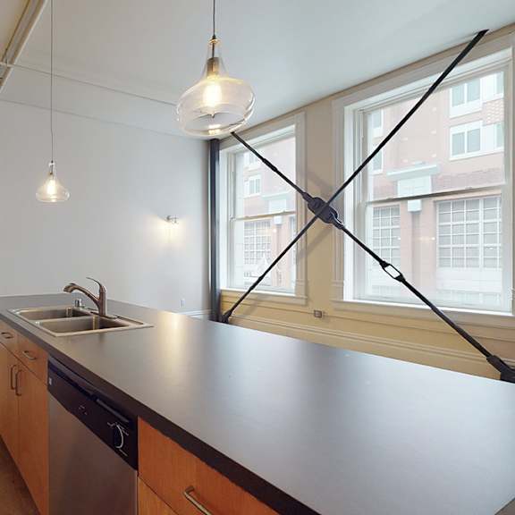 a kitchen with a black counter top and wooden cabinets.